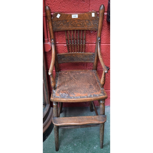 119 - A 19th century oak child's high chair, shaped cresting rail carved with a fruiting branch, above an ... 