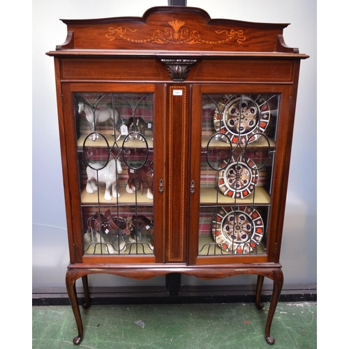 131 - An Edwardian mahogany display cabinet, shaped three-quarter gallery inlaid with ribbon-tied trailing... 