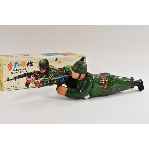 111 - A Chinese tinplate  Machine Gun Drill, battery operated, with crawling soldier with sparking gun, in... 