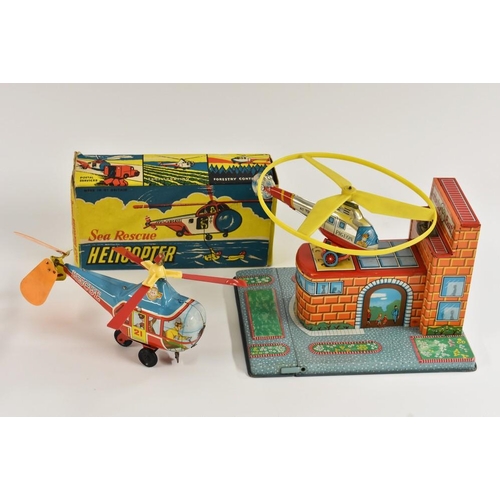 149 - A Pigeon tinplate Heliport, with key; a Great Britain Sea Rescue helicopter, tinplate, windup toy (2... 