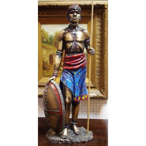 244 - A substantial bronzed figure, of a Maasai warrior in traditional tribal robes, picked out in colour