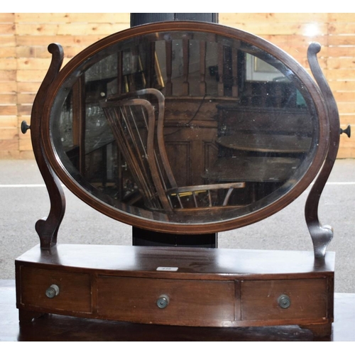436 - A 19th century mahogany dressing mirror, oval bevelled plate flanked by scrolling supports, the bow-... 