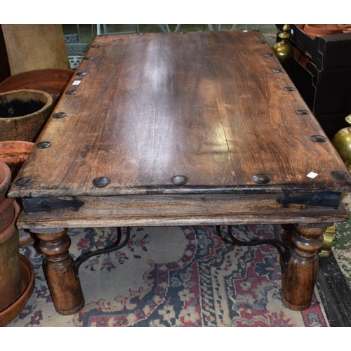 448 - An Indian style coffee table, rectangular studded top above a bracket bound frieze, turned spreading... 