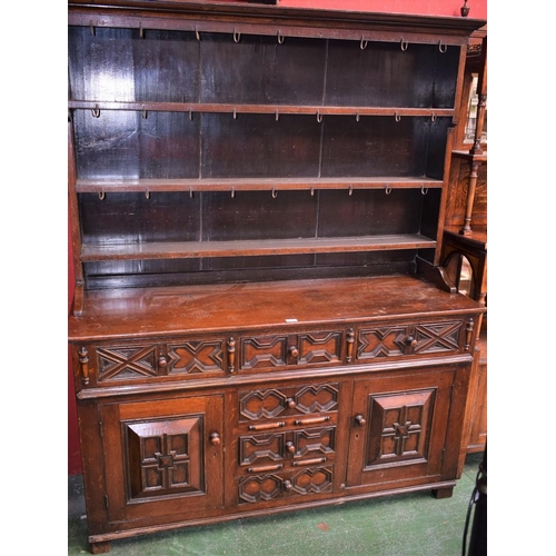 475 - A Jacobean Revival oak dresser, outswept cornice above three plate racks, the protruding base with t... 