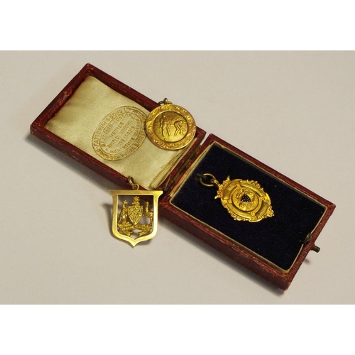 298 - A 9ct gold medal by Fattorini and sons, in original box, others similar, 14.1g gross, (3).