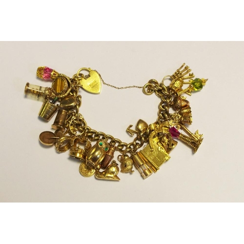 299 - A rolled gold charm bracelet with various gold charms, 93g gross.