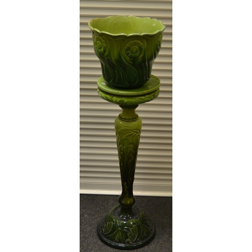 361 - A Bretby green glazed majolica jardiniere and stand, moulded in relief with stylised flowerheads and... 