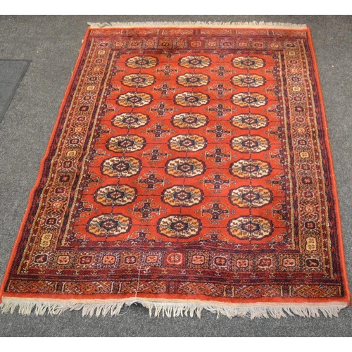 363 - A throw rug, geometric designs, in cobalt and cream, on a red ground.