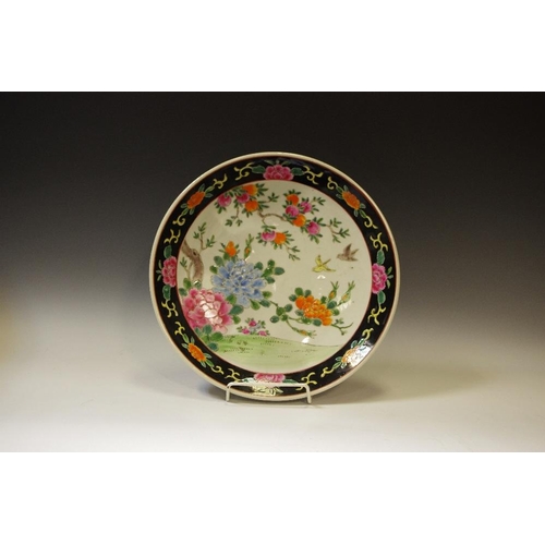 84 - A Japanese plate, decorated with colourful peonies and peaches, famille noir border, 30cm diam