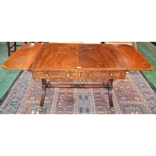 1576 - A Regency satinwood crossbanded mahogany sofa table, the rounded rectangular top with fall leaves ab... 