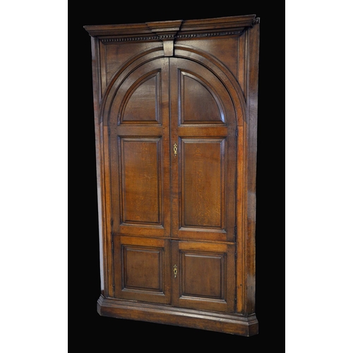 1590 - A George III oak floor standing corner cupboard, outswept break-centre cornice above a dentil apron ... 