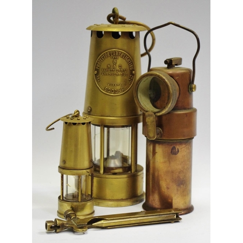 26 - A C.O.A.G Type B.E.3 Miners Safety Lamp, an Eccles projector lamp, a miniature miners lamp, a miners... 