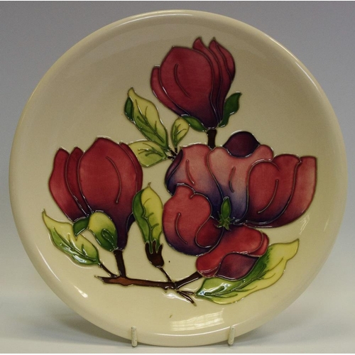 9 - A Moorcroft Clematis pattern plate, tube lined with large flowerhead and foliage, in tones of pink a... 