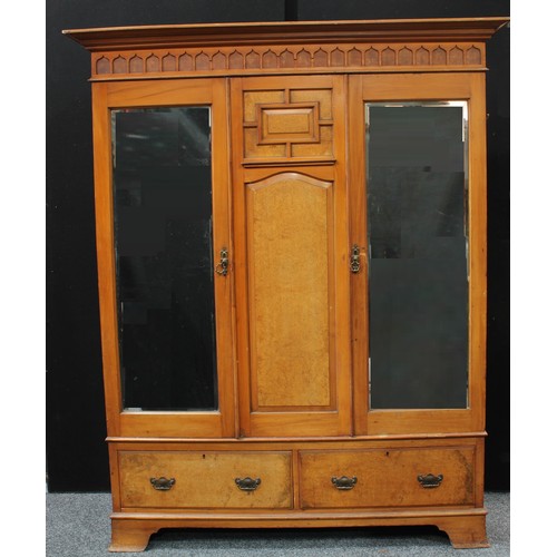 392 - An Arts & Crafts period walnut accented two piece bedroom suite, comprising a triple-door wardobe an... 