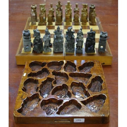 192 - A cased chess set with carved stone figures; a carved wooden multi-impression pastry mould (2)