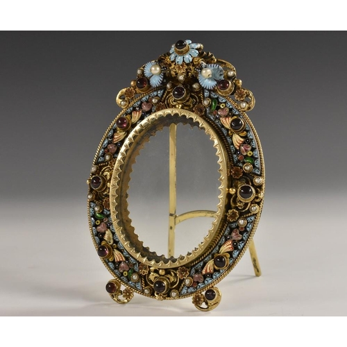 1140 - A 19th century Austrian silver-gilt, enamel and jewelled shaped oval easel photograph frame, crested... 