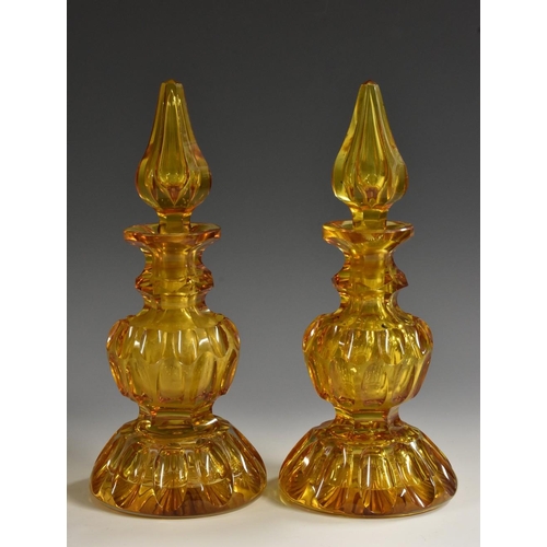 1167 - A pair of 19th century Bohemian amber glass baluster scent bottles, each reservoir with oval reserve... 