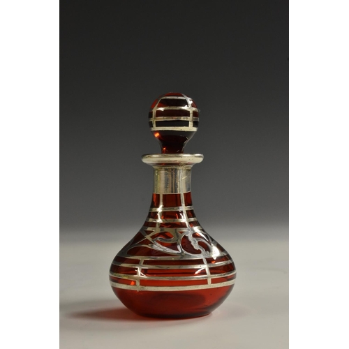 1175 - An Art Nouveau silver-mounted ruby glass scent bottle, of small proportions, overlaid with a band of... 