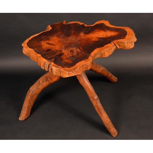 1253 - An unusual rustic yew wood cricket table, the shaped top formed from a transverse section, the base ... 