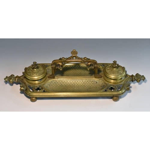 1260 - A Gothic Revival gilt brass partners' inkstand, in the Pugin manner, arched carrying handle with dra... 