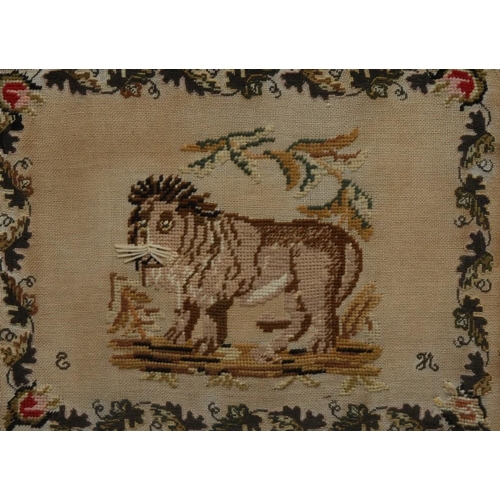 1268 - An early Victorian wool work picture, embroidered with a naive lion, by EH, monogrammed, within a bo... 