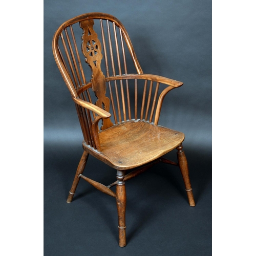 1294 - An early 19th century yew and elm Windsor elbow chair, hooped back, shaped and pierced wheel splat, ... 