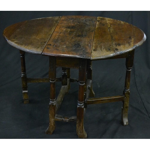 1299 - An early 18th century oak gateleg table, of small proportions, oval top, turned legs, outswept feet,... 