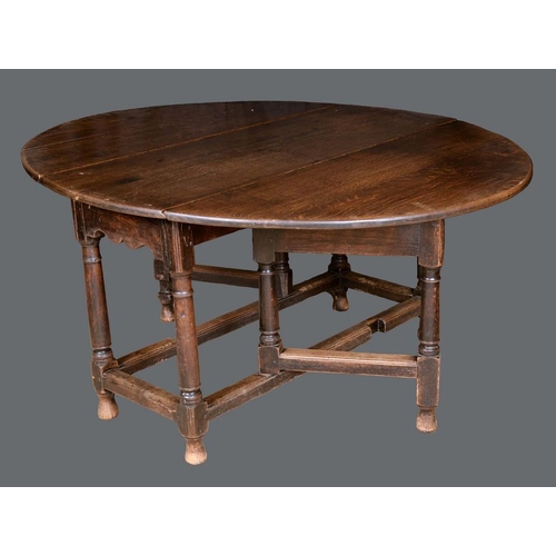 1300 - An early 18th century oak gateleg dining table, turned legs, rectangular stretcher, 71cm high, 123cm... 