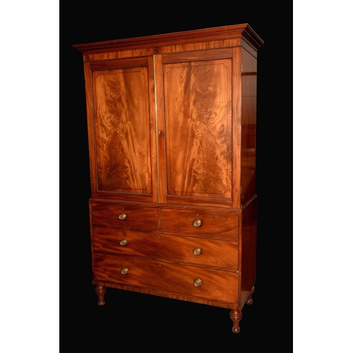 1350 - A well figured post-Regency mahogany linen press, outswept cornice above a pair of rectangular panel... 