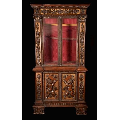 1372 - A Renaissance Revival walnut and parcel-gilt bookcase, dentil cornice above a pair of rectangular gl... 