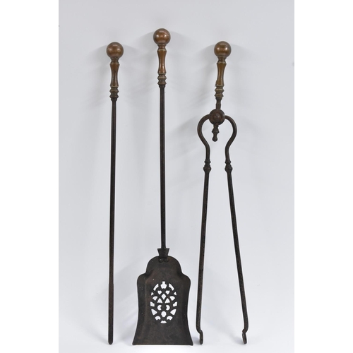 1414 - A set of George III steel and brass fire irons, comprising shovel, tongs and poker, globular pommels... 