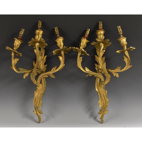 1441 - A pair of Rococo Revival ormolu three-light wall sconces, cast throughout with acanthus, 45cm long