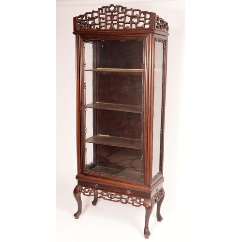 1451 - A Chinese padouk wood display cabinet, shaped cresting above a rectangular glazed door enclosing adj... 