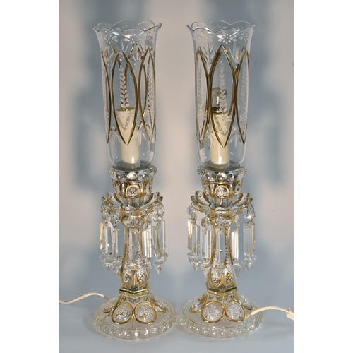 1457 - A pair of clear glass lustres, applied with white enamel flowers, picked out in gilt, converted to e... 