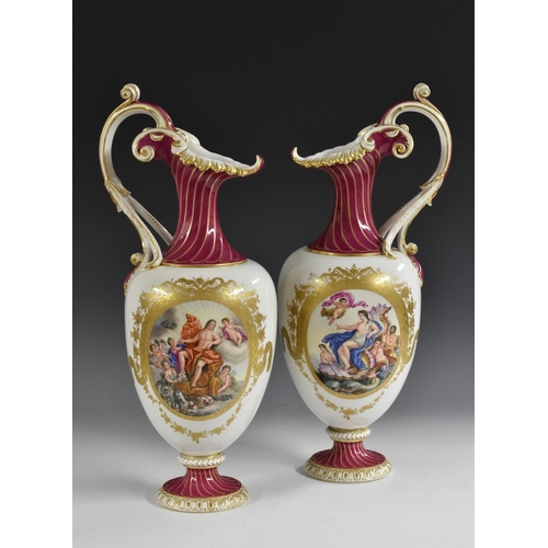 257 - A pair of Berlin pedestal ewers, decorated with classical figures within gilt laurel and rose cartou... 