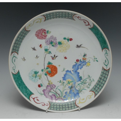 314 - A Chinese circular dish, decorated in the famille rose palette with stylised flowers, grasses and bi... 