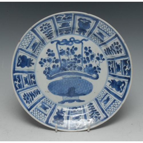 316 - A Chinese circular plate, decorated in underglaze blue with a basket of stylised flowers and foliage... 