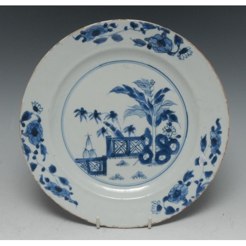 317 - A Chinese circular plate, decorated in underglaze blue with a fence and bamboo, the rim with stylise... 