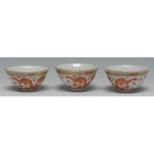 348 - Three small Chinese bowls, decorated with scrolling dragons and clouds in iron red, 6cm diam, Qianlo... 