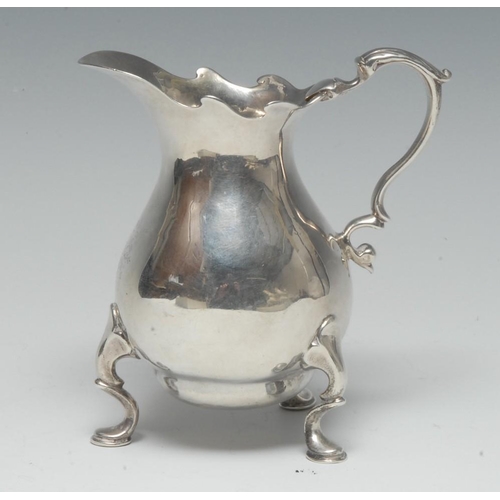 495 - A George II silver bellied cream jug, of usually substantial gauge, shaped rim, acanthus-capped doub... 