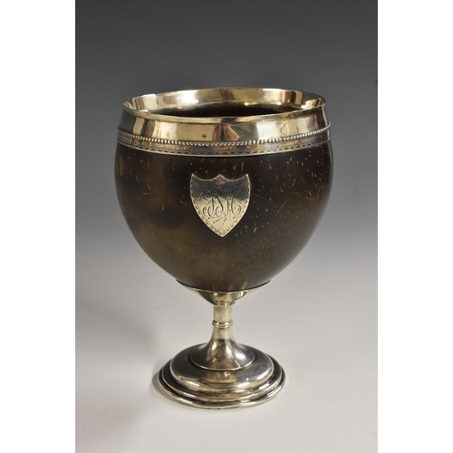 500 - A George III and later silver mounted coconut cup, broad rim with beaded and bright-cut borders abov... 