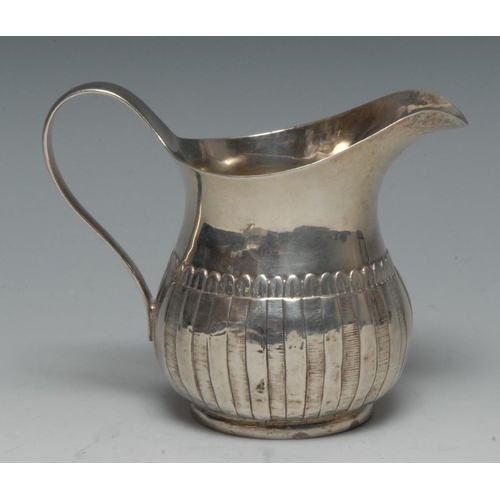 501 - A George III Irish silver lotus-fluted ovoid cream jug, scroll handle, 10cm high, probably Thomas Jo... 