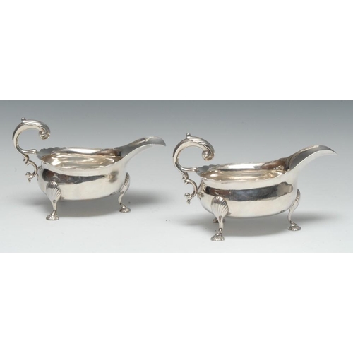 584 - A pair of large 18th century Irish Provincial silver sauce boats, acanthus capped flying scroll hand... 