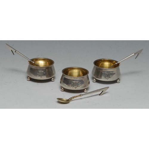 594 - A set of three 19th century Russian silver cauldron salt cellars and spoons, quite plain, gilt reser... 