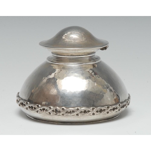 680 - Omar Ramsden - an Arts and Crafts silver domed inkwell, hinged cover, planished overall and applied ... 