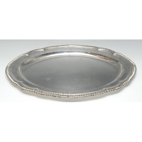 682 - Paul Storr - a large George III silver shaped oval meat dish, gadrooned border, crested, 55.5cm wide... 