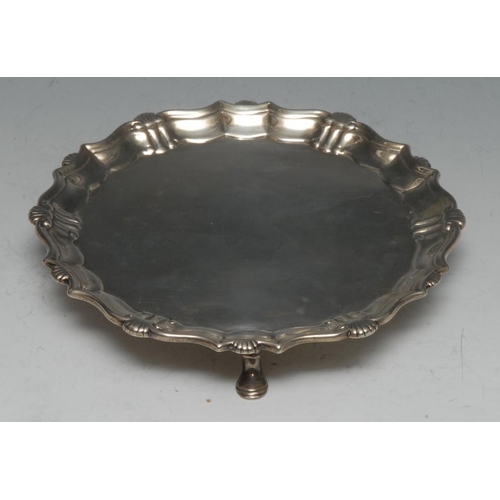 694 - A George II silver shaped circular card waiter, fluted shell and S-scroll border, hoof feet, 17cm di... 