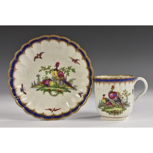 83 - A Worcester fluted coffee cup and saucer, decorated by Dr Davis with fabulous birds, blue and gilt b... 