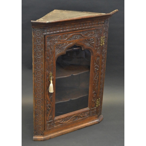 777 - A George III oak splay fronted corner cabinet, later carved with foliage, shaped glazed door, shaped... 