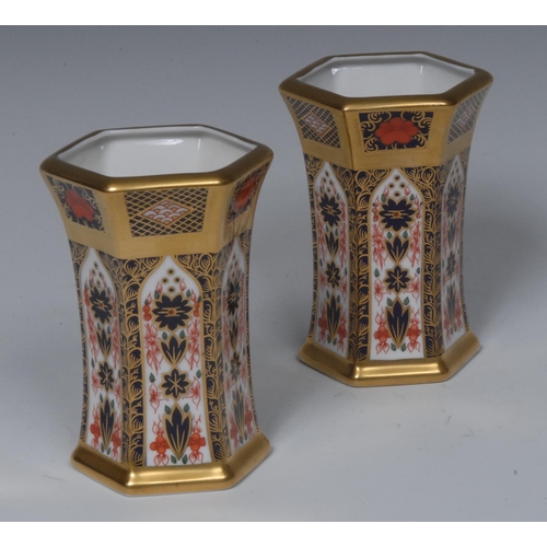 114 - A pair of Royal Crown Derby 1128 pattern hexagonal vases, gold borders, 11cm high, printed marks, bo... 